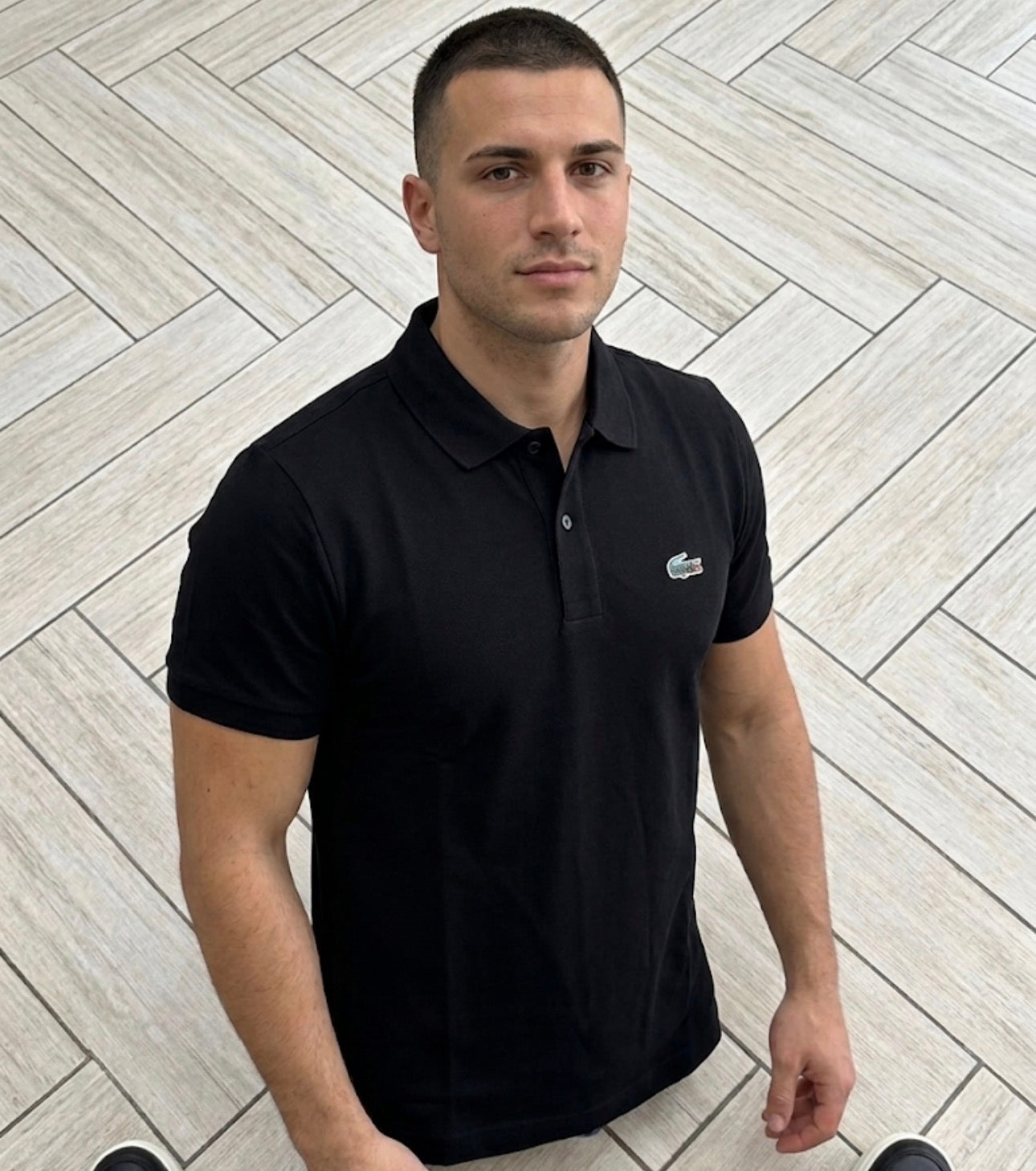 Polo Lacoste Nera Basic con logo multicolor